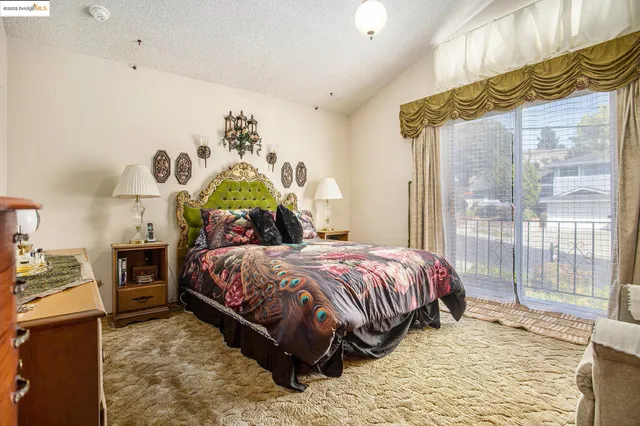a bedroom with a bed table and window