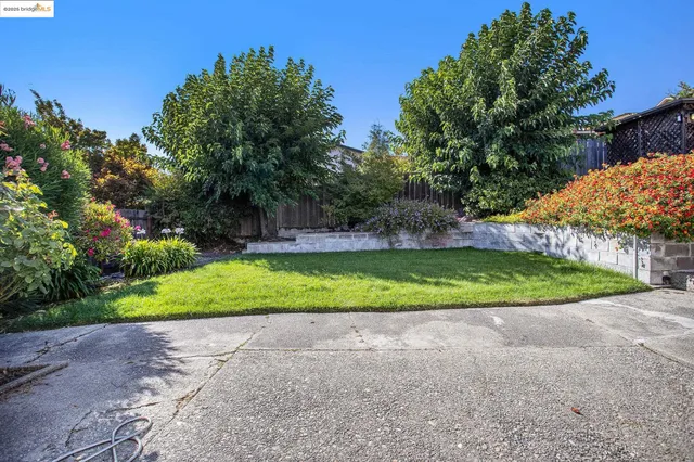 a front view of multiple house with yard patio and outdoor seating