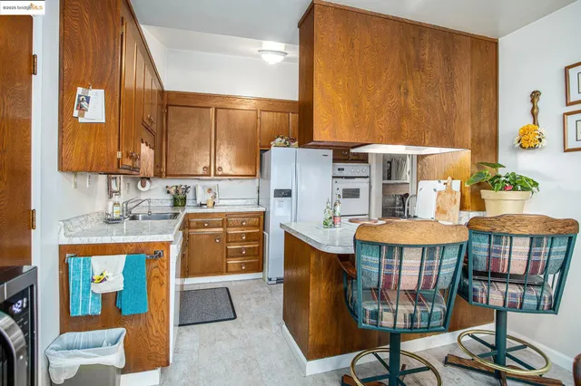 a kitchen that has a table chairs and a refrigerator
