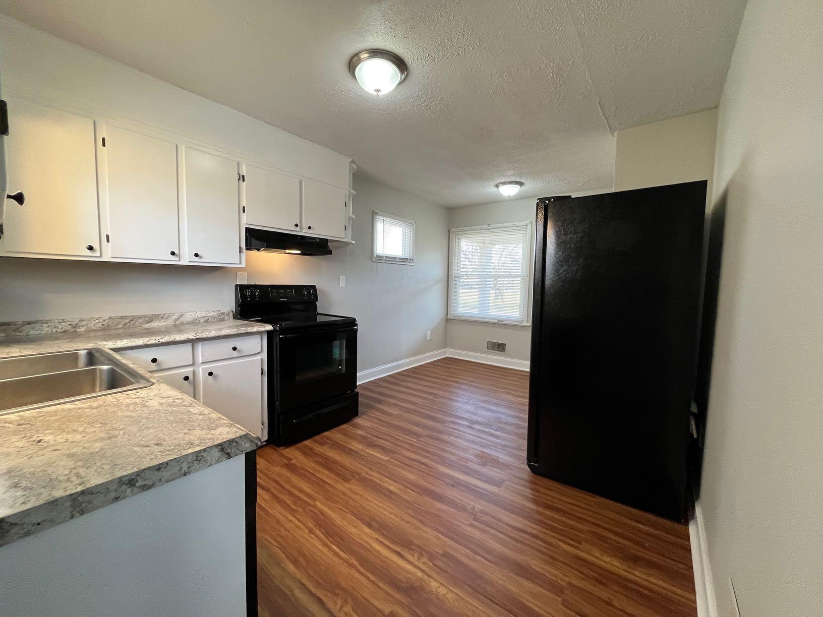 1939 Barrington Drive Northwest Roanoke, VA 24017 - Photo 13 of 14 a kitchen with granite countertop white cabinets and black appliances