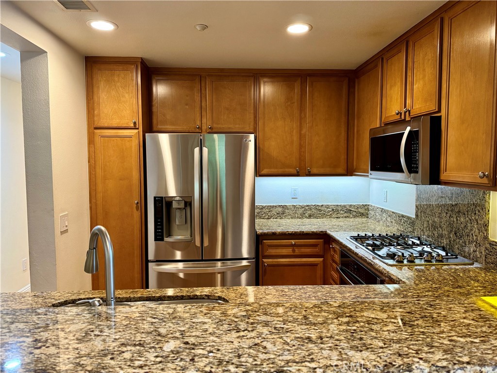 238 Coral Rose Irvine, CA 92603 - Photo 5 of 19 a kitchen with stainless steel appliances granite countertop a refrigerator and a stove
