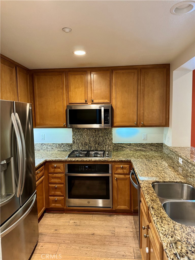 238 Coral Rose Irvine, CA 92603 - Photo 6 of 19 a kitchen with stainless steel appliances granite countertop a stove a sink and a refrigerator