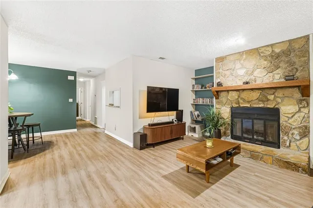 a living room with furniture a flat screen tv and a fireplace