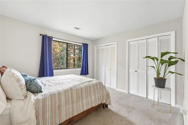 a bedroom with a bed table and a window