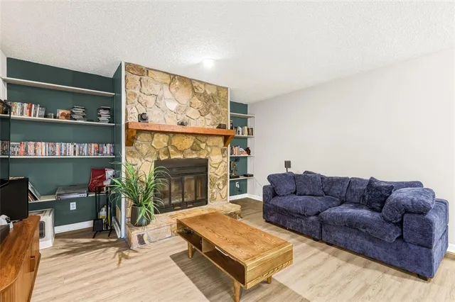 a living room with furniture a flat screen tv and a fireplace