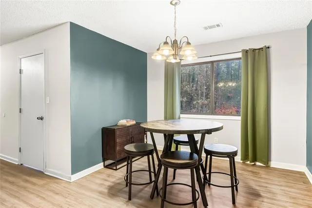 a view of a dining room with furniture a chandelier and wooden floor