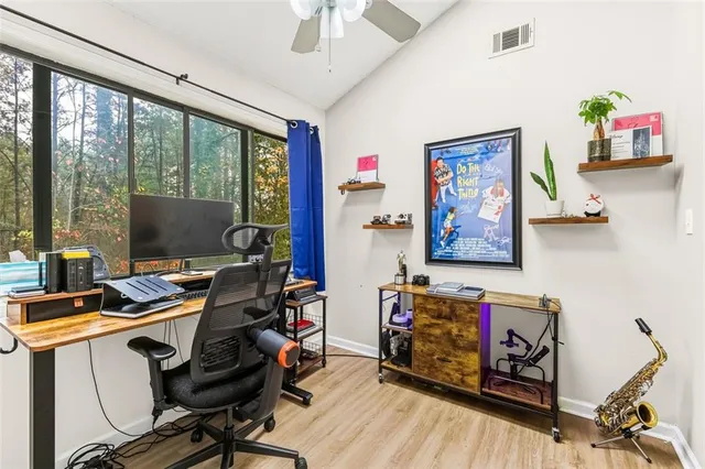 a view of a workspace with furniture and a window