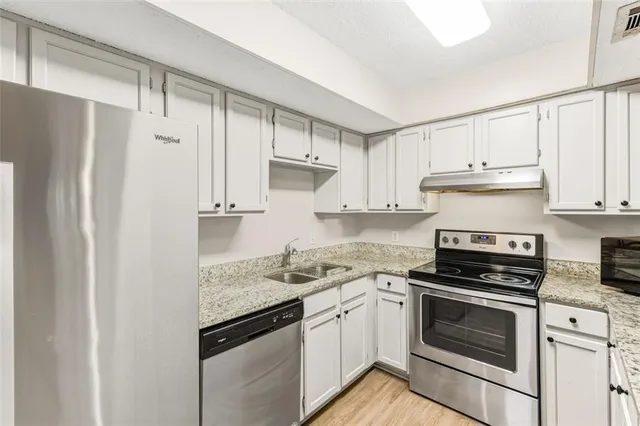 a kitchen with white cabinets and white appliances