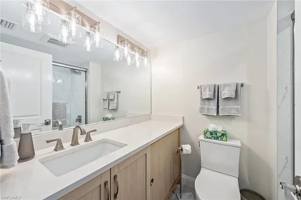 a bathroom with a sink mirror vanity and toilet