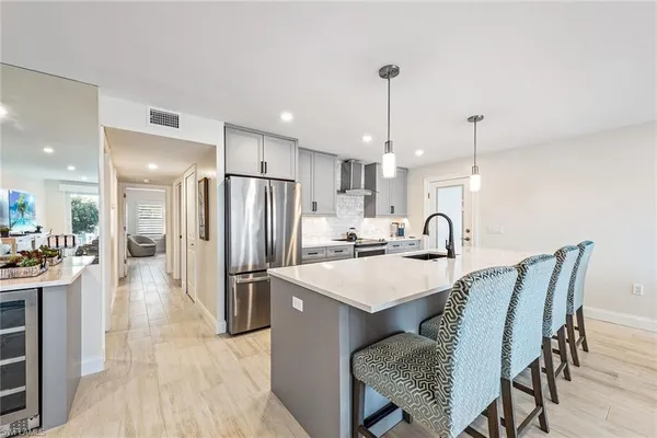 a kitchen with stainless steel appliances a dining table chairs and wooden floor