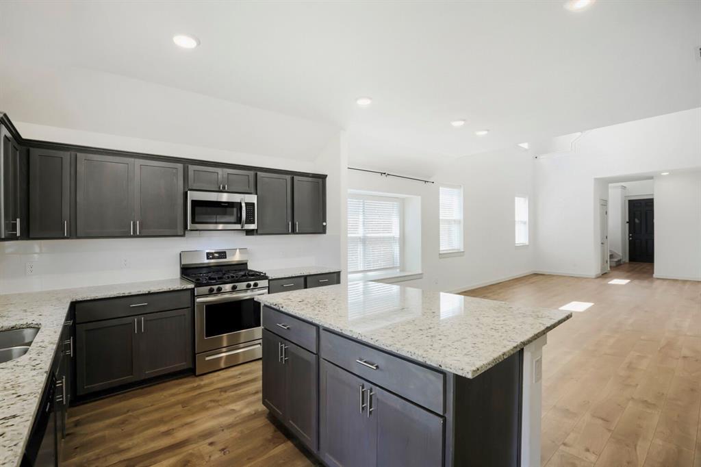 1368 Cedar Street Forney, TX 75126 - Photo 10 of 29 Kitchen featuring stainless steel appliances, dark wood-finish cabinetry, and light-toned countertops