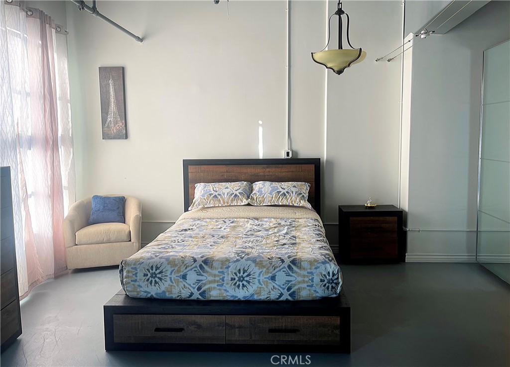 312 West 5th Street, Unit 1003 Los Angeles, CA 90013 - Photo 2 of 20 a bedroom with a bed and a couch