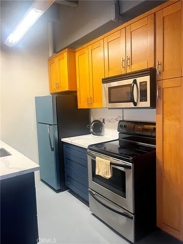 a kitchen with stainless steel appliances wooden cabinets and a stove top oven