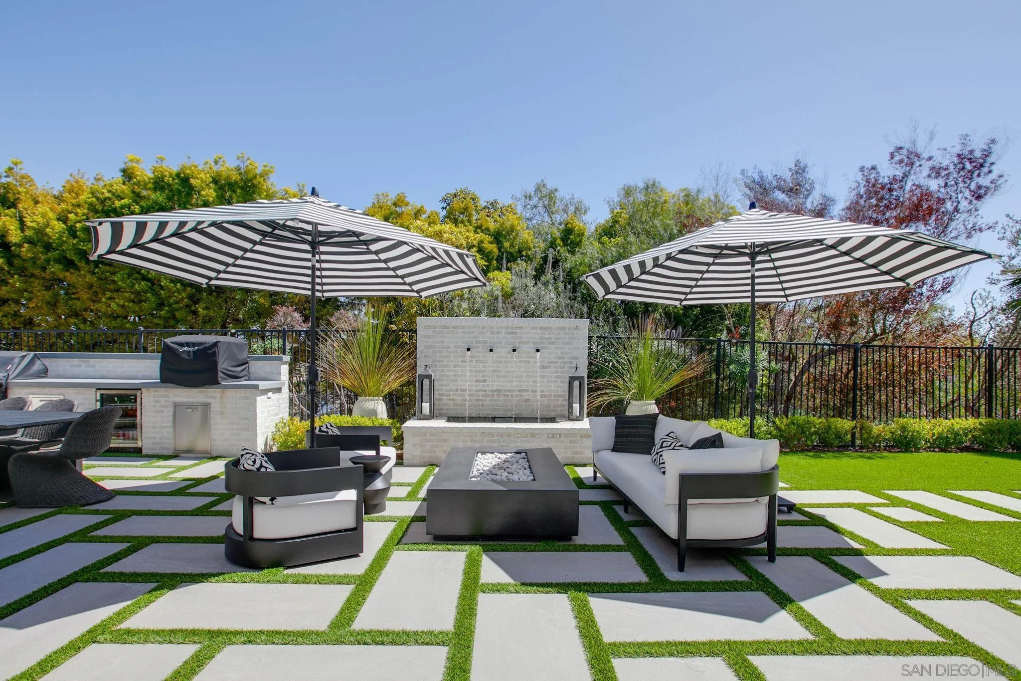 329 Chopin Way Cardiff, CA 92007 - Photo 37 of 47 a view of a patio with dining table and chairs under an umbrella with a barbeque