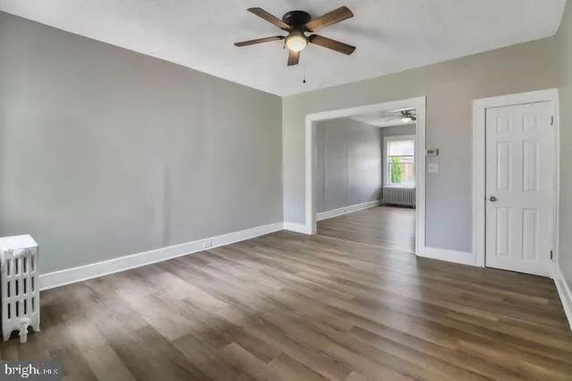 a view of a livingroom with wooden floor and a ceiling fan
