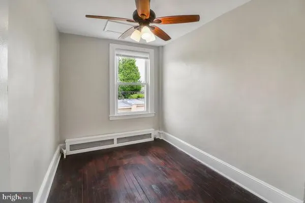 an empty room with a window and wooden floor