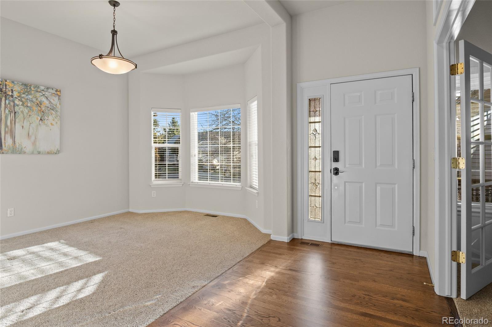 20800 Omaha Avenue Parker, CO 80138 - Photo 3 of 38 a view of an empty room with window and wooden floor