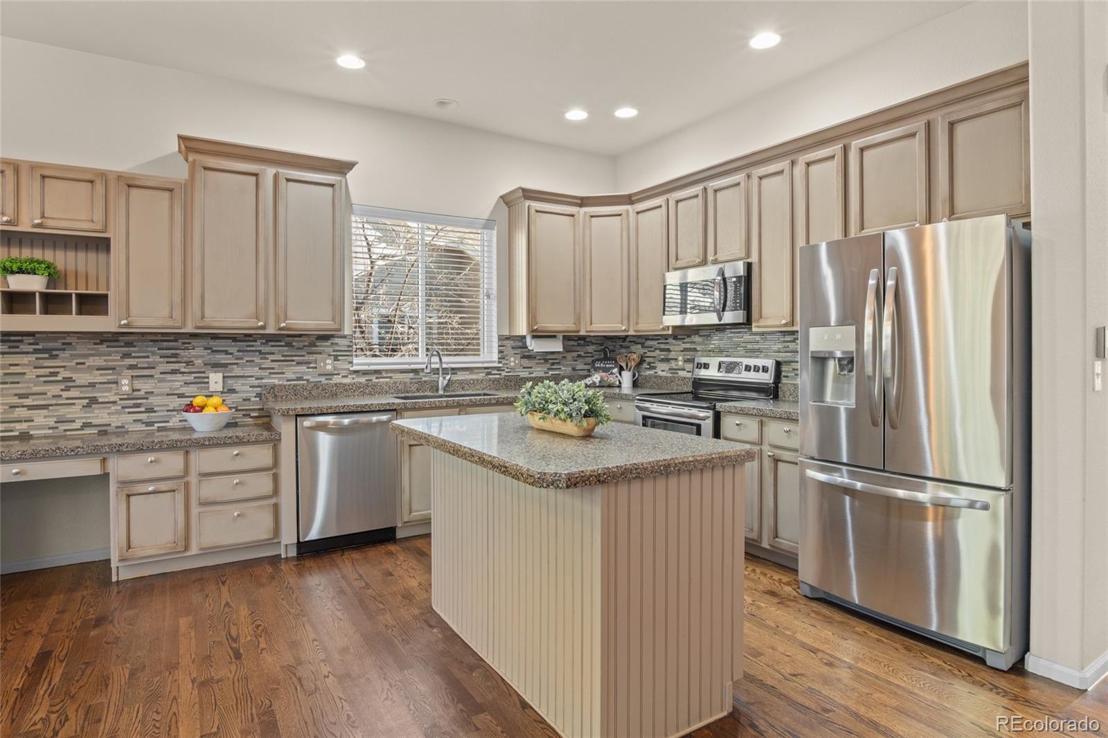 20800 Omaha Avenue Parker, CO 80138 - Photo 9 of 38 a kitchen with stainless steel appliances granite countertop a refrigerator a sink dishwasher a stove and white cabinets with wooden floor