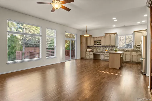 a kitchen with stainless steel appliances granite countertop a stove top oven a refrigerator a sink with a dining table and chairs