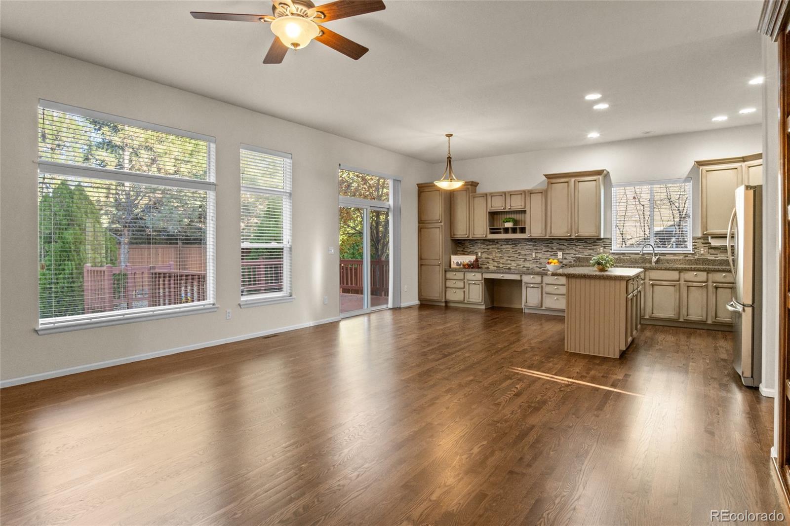 20800 Omaha Avenue Parker, CO 80138 - Photo 10 of 38 a kitchen with stainless steel appliances granite countertop a stove top oven a refrigerator a sink with a dining table and chairs