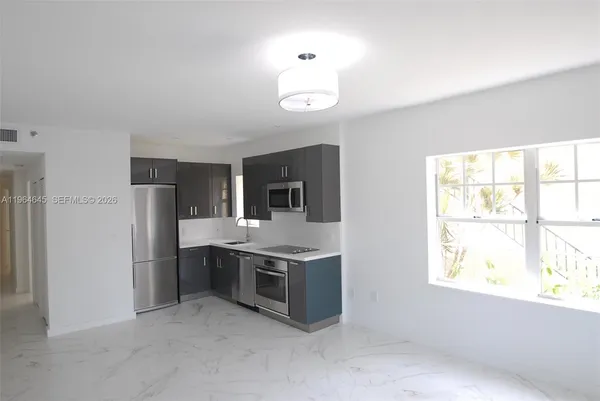 a kitchen with stainless steel appliances granite countertop a stove a refrigerator and a sink