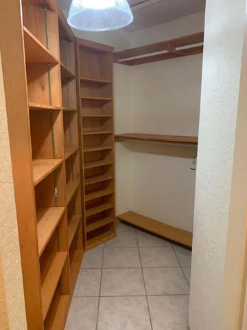a view of walk in closet with empty racks