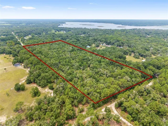 a view of a green field with mountains in the background