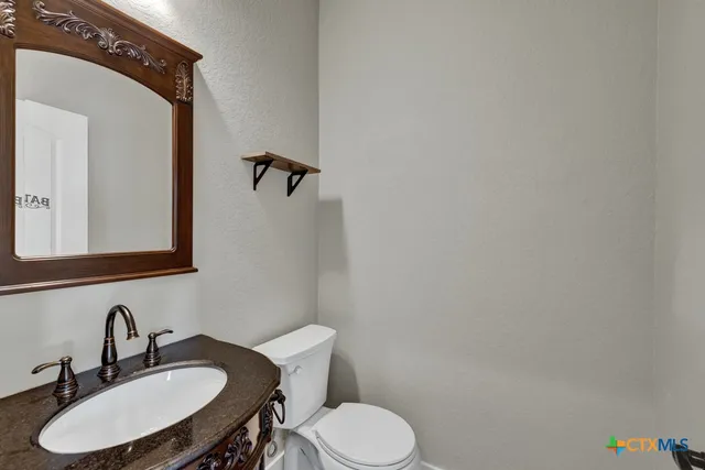 a bathroom with a toilet a sink and mirror