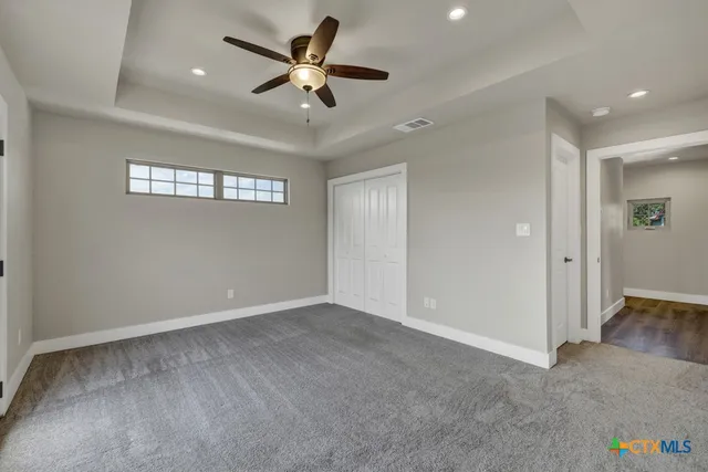 an empty room with a ceiling fan and a window