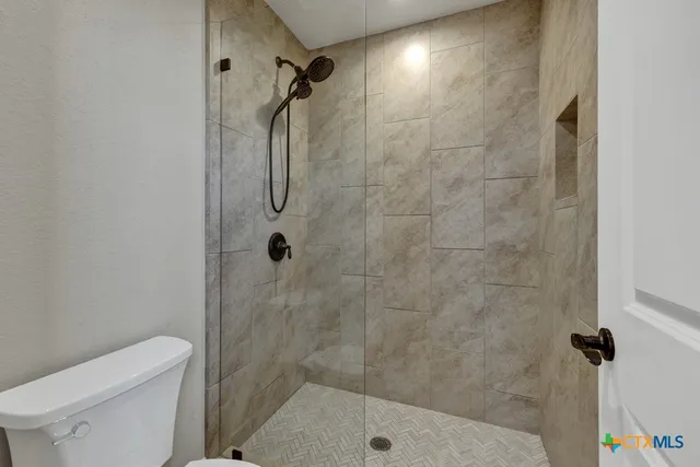 a bathroom with a shower toilet and sink