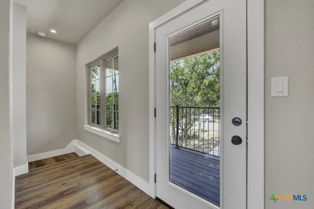 a view of an entryway with wooden floor and front door