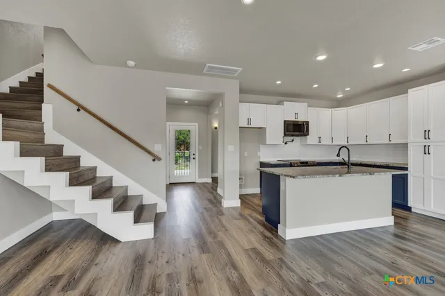 a view of kitchen with sink microwave and stove