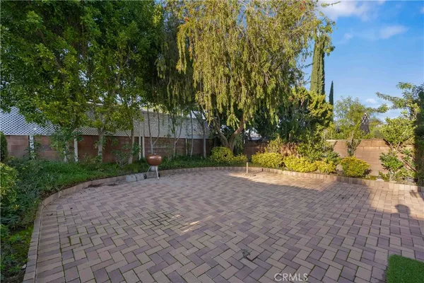 a view of a house with a yard and potted plants