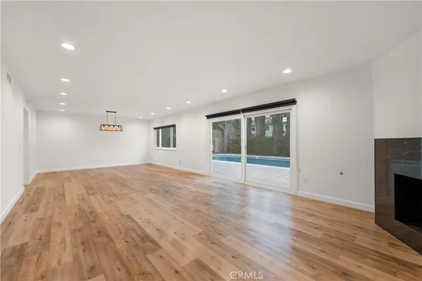 a view of empty room with wooden floor and fireplace