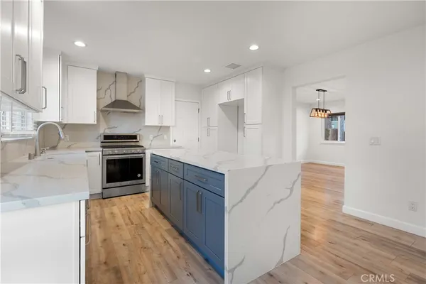 a kitchen with stainless steel appliances granite countertop a stove a sink and a refrigerator