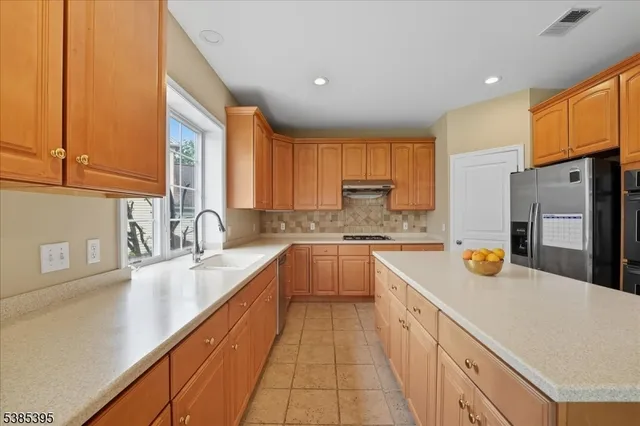 a large kitchen with a sink a window and appliances