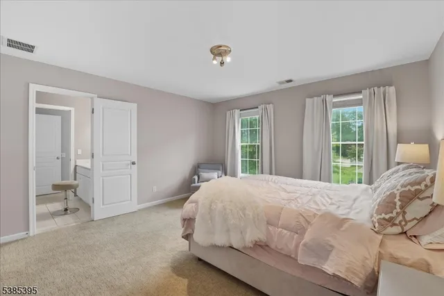 a bedroom with a bed and large windows
