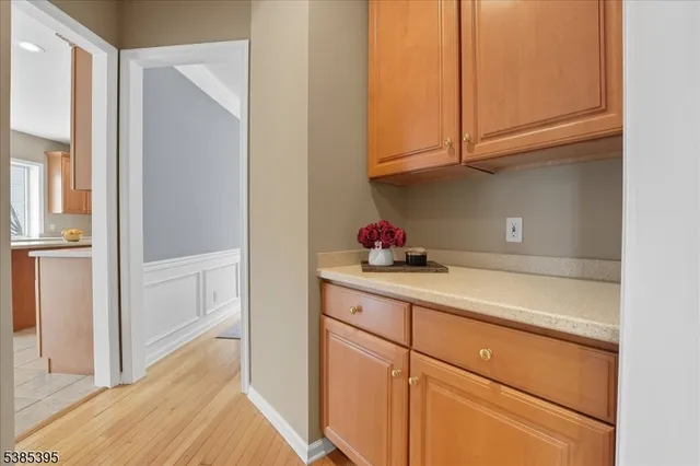 a kitchen with granite countertop white cabinets and utility room