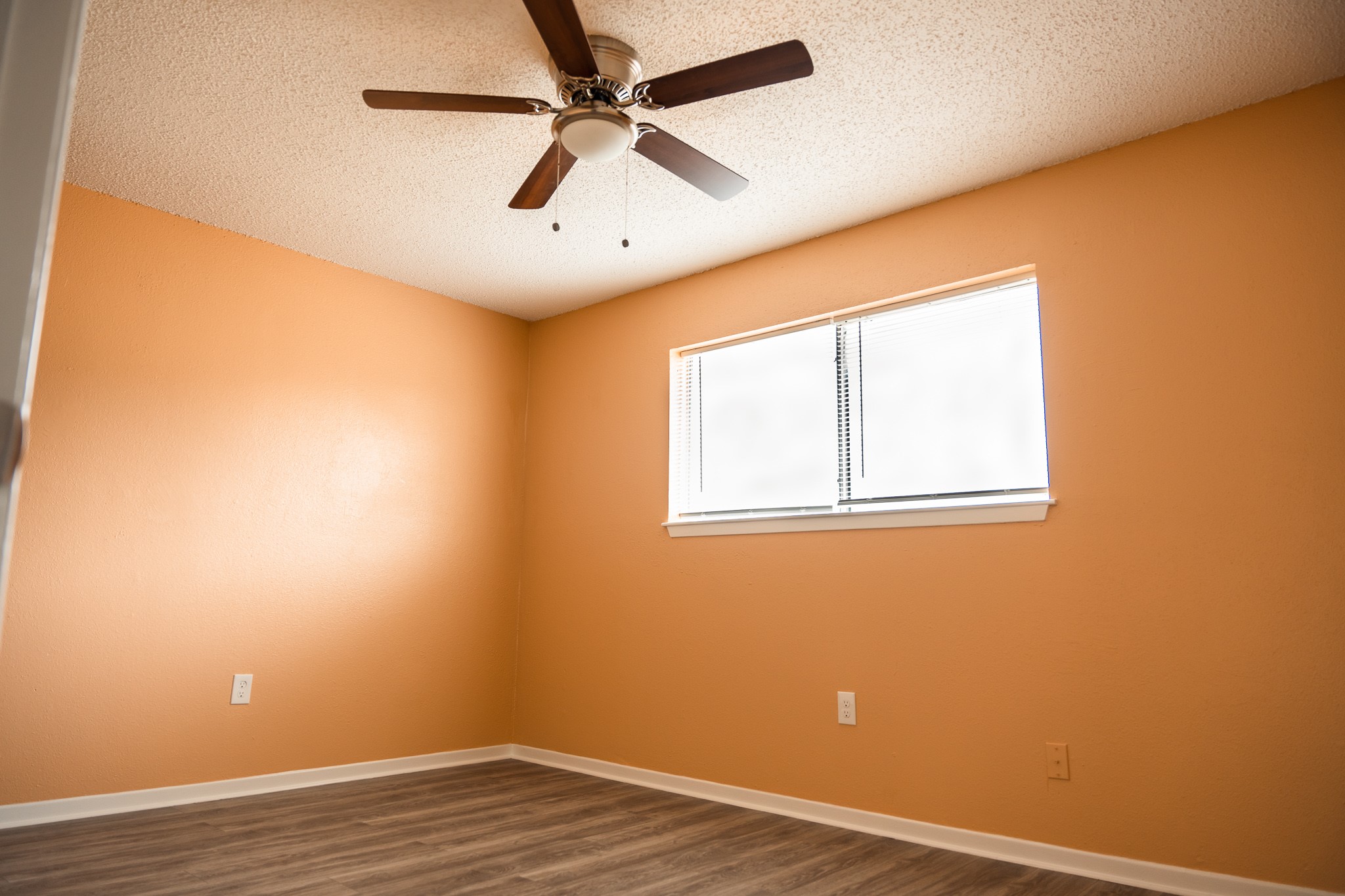 1506 Eagle Lake Road Sealy, TX 77474 - Photo 12 of 17 an empty room with wooden floor fan and windows