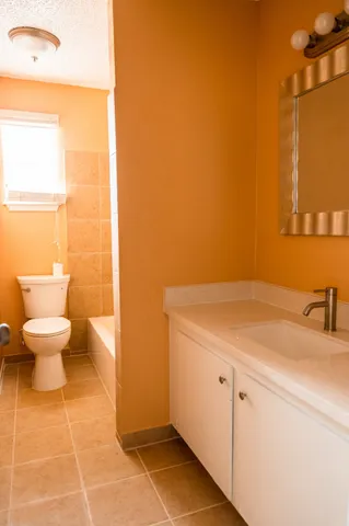 a bathroom with a sink a toilet and a mirror