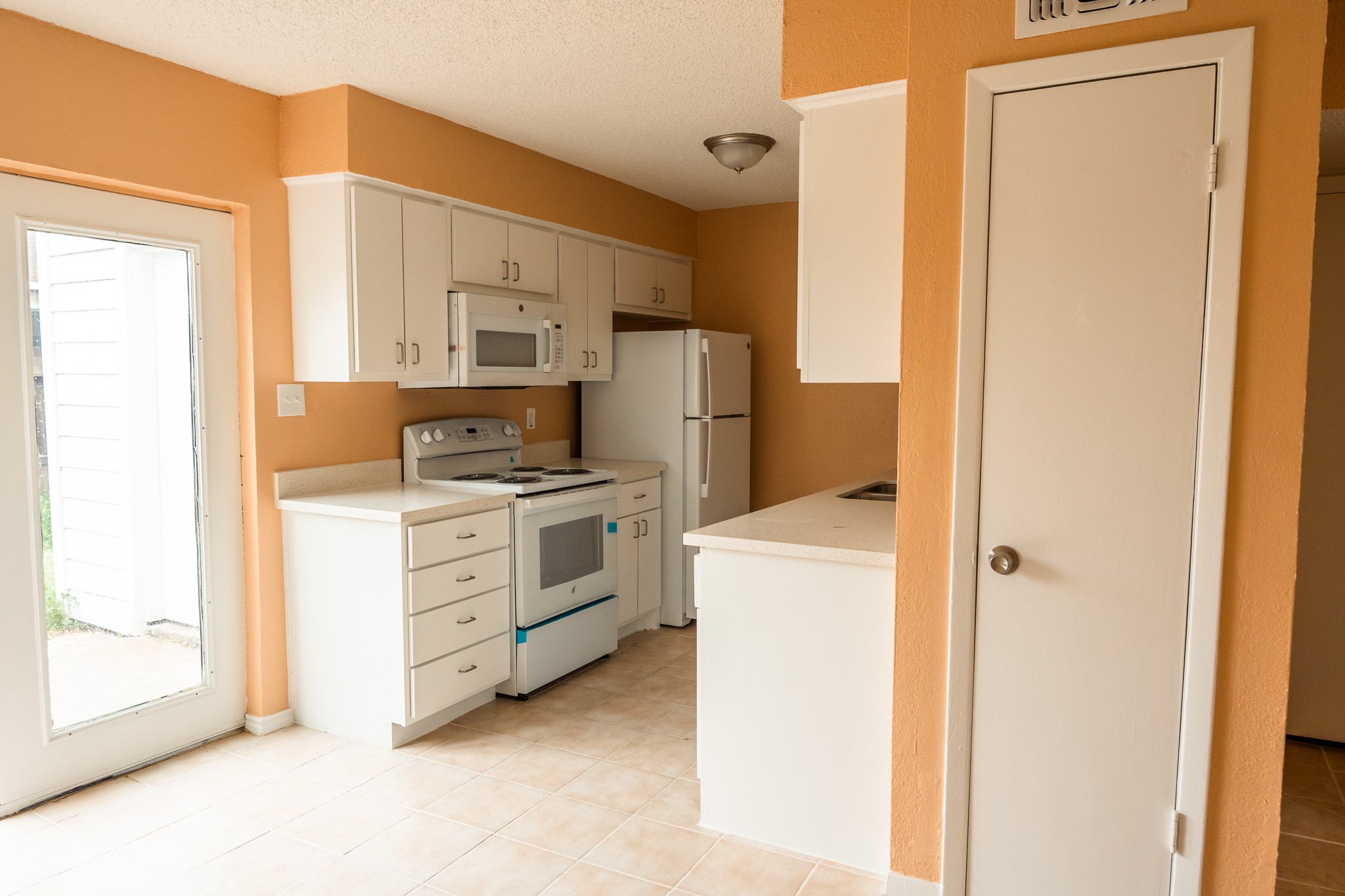 1506 Eagle Lake Road Sealy, TX 77474 - Photo 5 of 17 a kitchen with white cabinets and white appliances