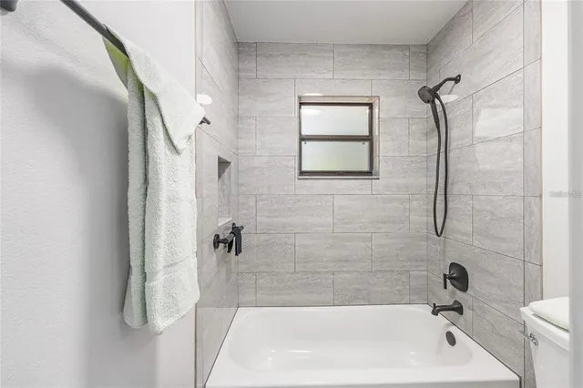 a bathroom with a tub shower and vanity