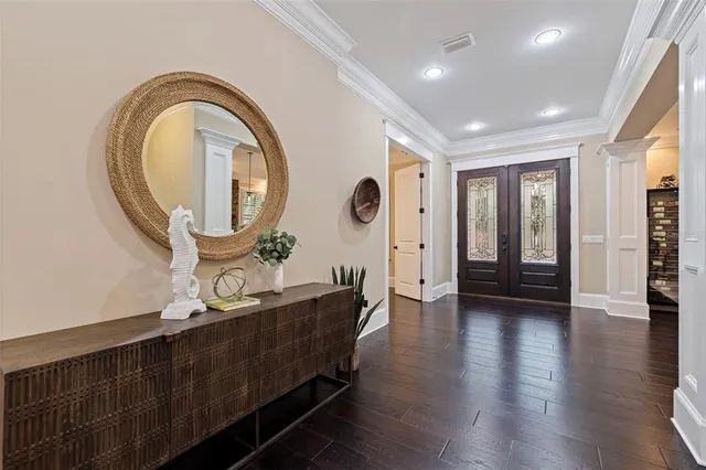 an open kitchen with granite countertop a stove a sink a dining table and chairs with wooden floor