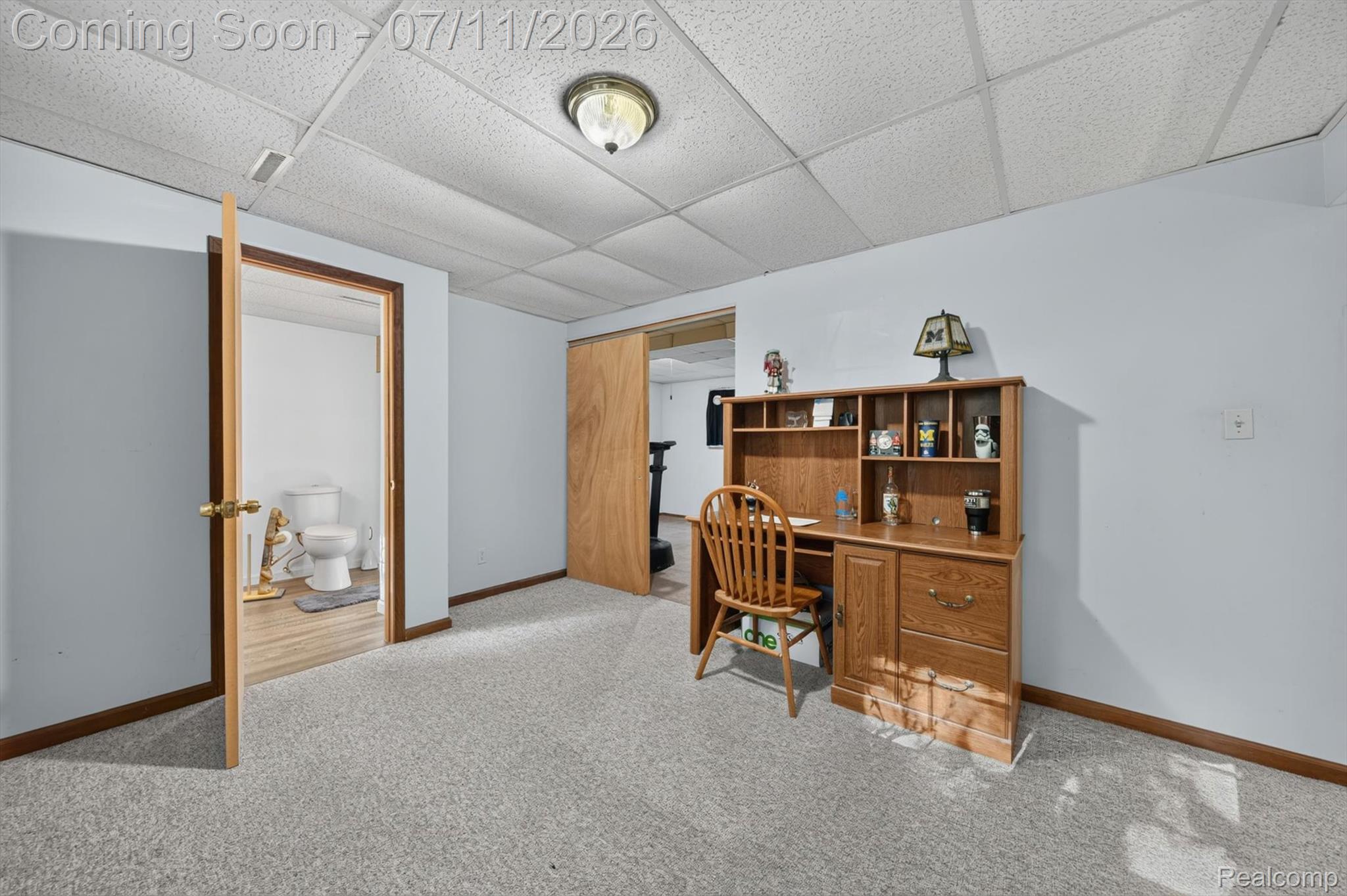 4430 North Center Road Flint, MI 48506 - Photo 27 of 49 Carpeted room with light blue walls, wood trim, and a drop ceiling