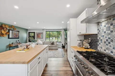 a large kitchen with stainless steel appliances granite countertop a lot of counter space and a sink