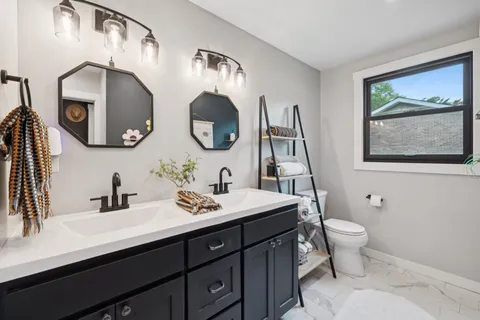 a bathroom with a toilet a sink and a mirror