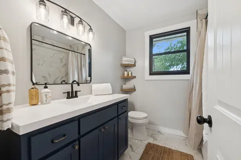 a bathroom with a toilet sink and mirror