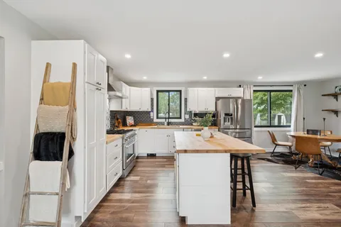 a large kitchen with kitchen island a large counter space a sink appliances and cabinets
