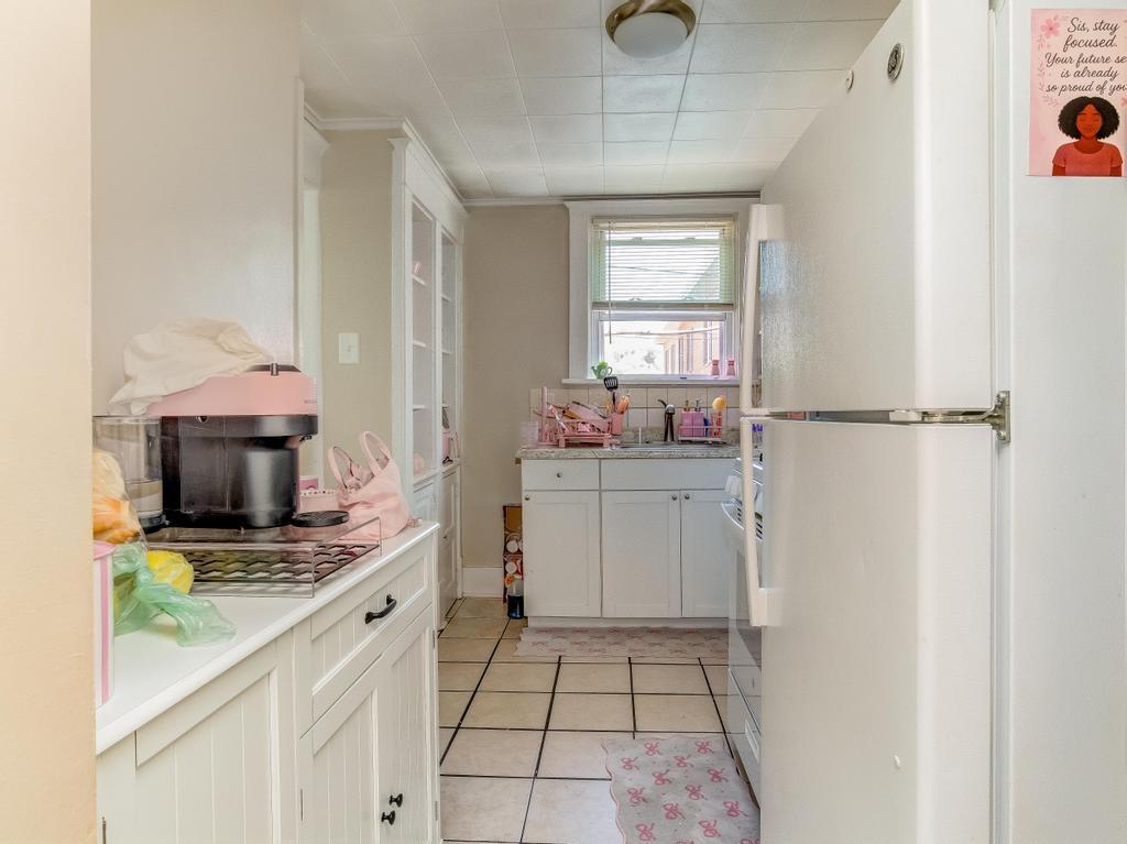 282 9th Street Ambridge, PA 15003 - Photo 4 of 21 a kitchen with a microwave a stove and white cabinets