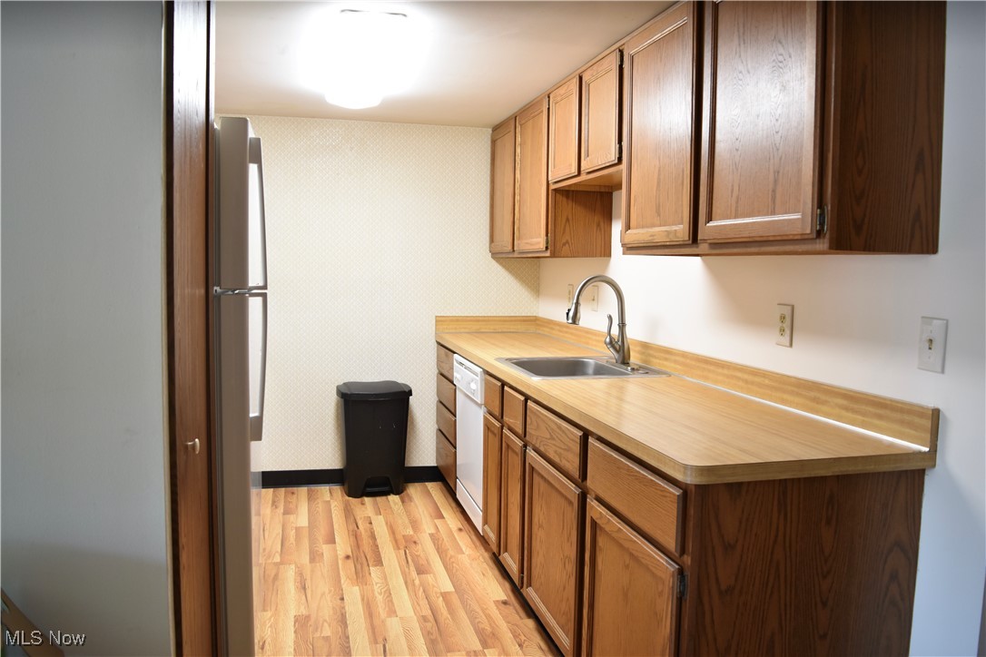 3257 Mayfield Road Cleveland, OH 44118 - Photo 2 of 20 Kitchen featuring dishwasher, a sink, light countertops, freestanding refrigerator, and light wood-style floors